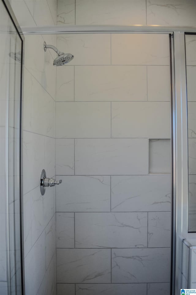 bathroom featuring a shower with door