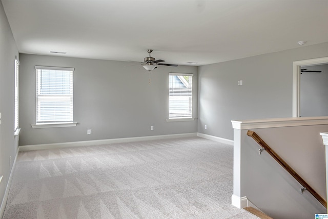 carpeted empty room featuring ceiling fan and a healthy amount of sunlight