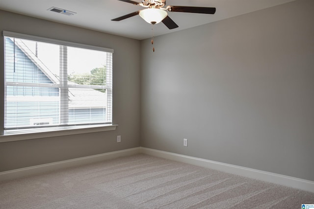 empty room featuring ceiling fan and light carpet