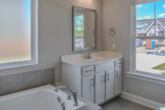 bathroom with tile patterned floors, a bathtub, and vanity