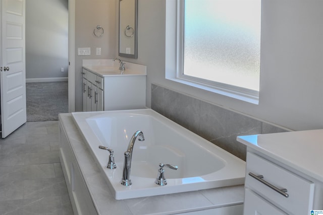 bathroom with vanity and tiled tub