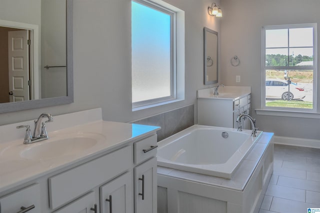 bathroom with a bath, tile patterned flooring, vanity, and a healthy amount of sunlight