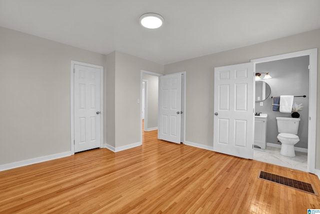 unfurnished bedroom with light wood-type flooring, visible vents, and baseboards