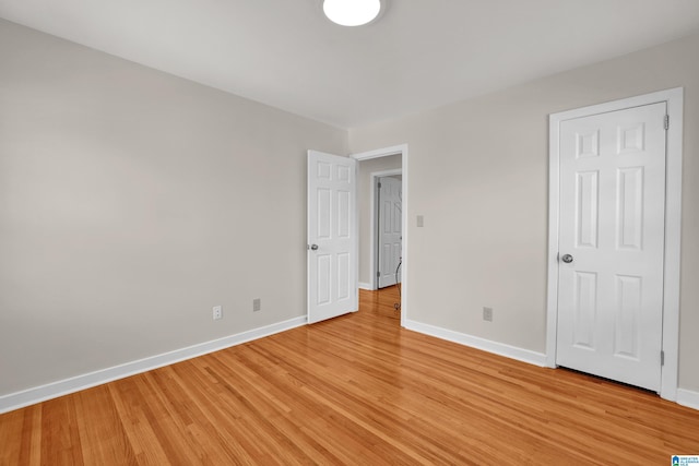 unfurnished bedroom with light wood-style flooring and baseboards