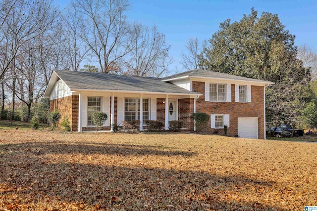 tri-level home with a garage, a front yard, and brick siding