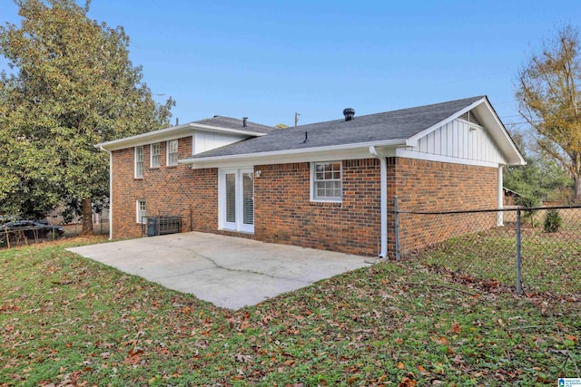 back of house featuring a patio area, fence, board and batten siding, and brick siding