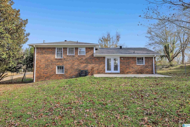 rear view of property with a patio, cooling unit, brick siding, fence, and a lawn