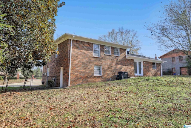 rear view of house with a yard and central AC unit