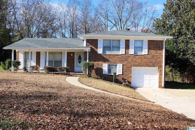 split level home with concrete driveway, brick siding, and an attached garage