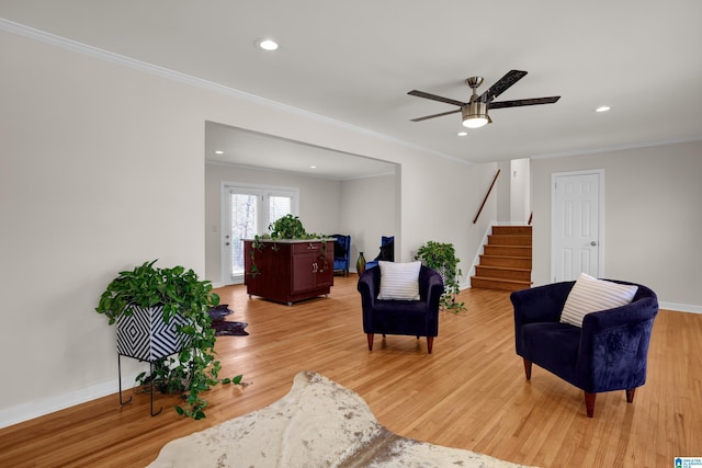 living room featuring light hardwood / wood-style floors, ceiling fan, and crown molding