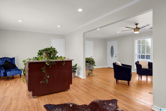 living room featuring recessed lighting, ornamental molding, a ceiling fan, light wood-type flooring, and baseboards