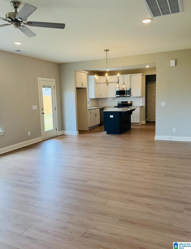 500 Avondale Ln, Pell City, AL 35128 - kitchen featuring stainless steel appliances, open floor plan, a center island, white cabinetry, and decorative backsplash