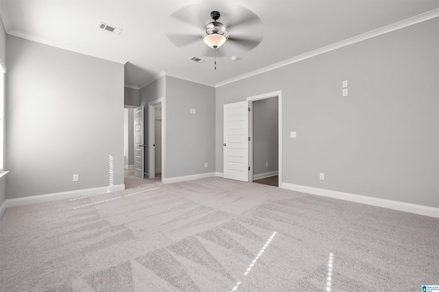 empty room with ceiling fan, light colored carpet, and crown molding