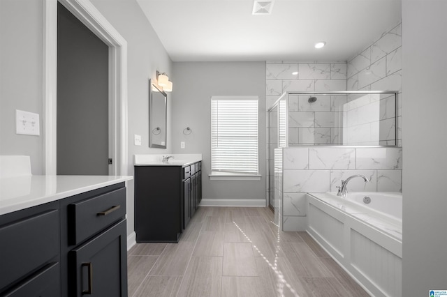 bathroom with vanity and separate shower and tub