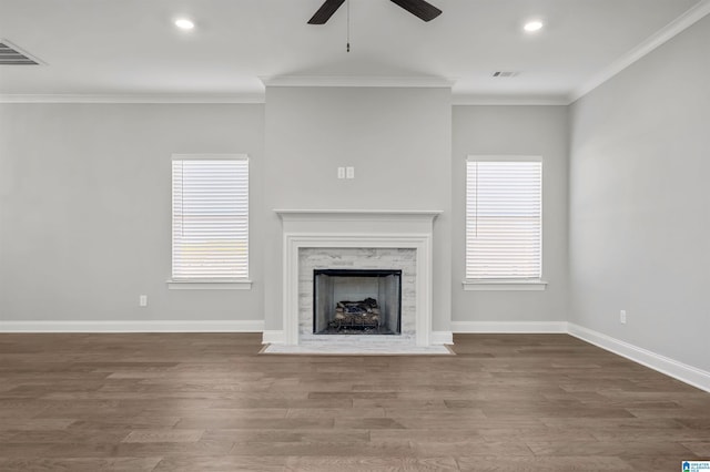 unfurnished living room featuring a fireplace, hardwood / wood-style flooring, ceiling fan, and crown molding