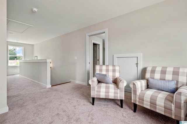 sitting room with carpet flooring, baseboards, and attic access