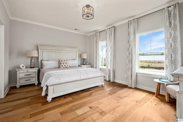 bedroom featuring light wood-style floors, multiple windows, and crown molding