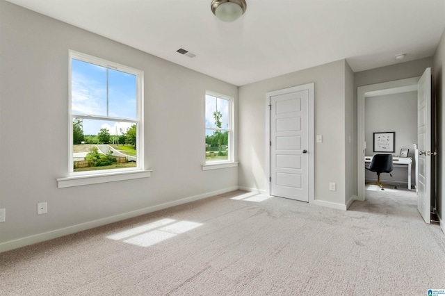 unfurnished bedroom with carpet floors, baseboards, and visible vents