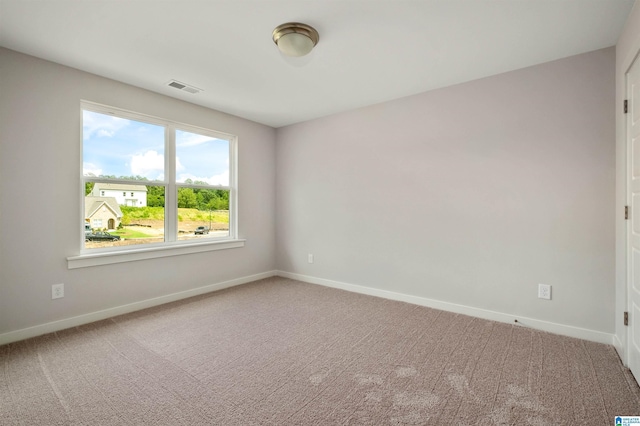 carpeted spare room featuring visible vents and baseboards