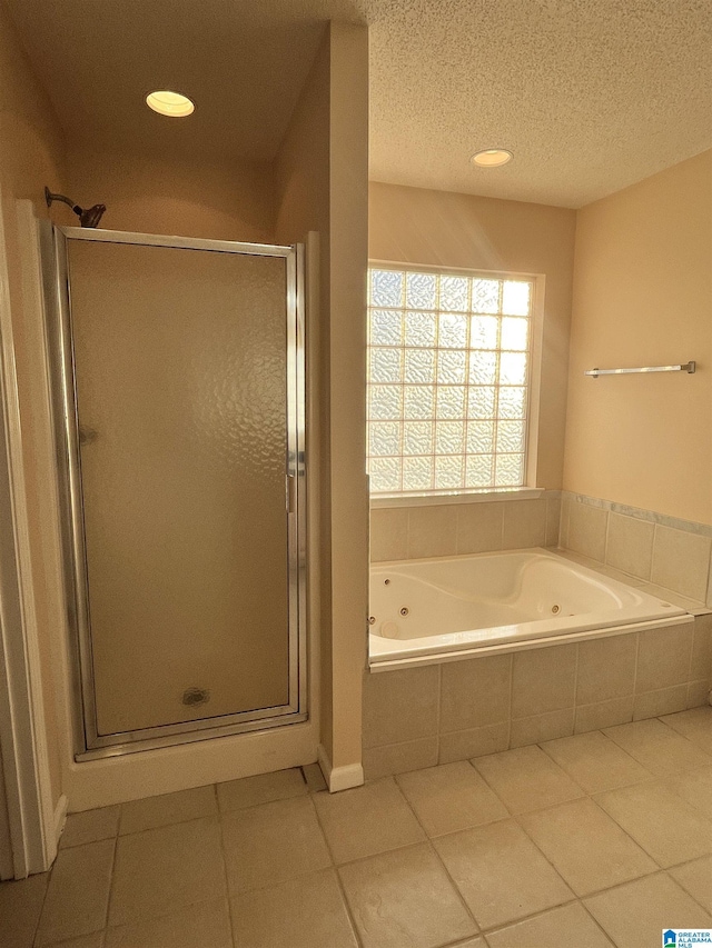 bathroom featuring tile patterned floors, separate shower and tub, and a textured ceiling