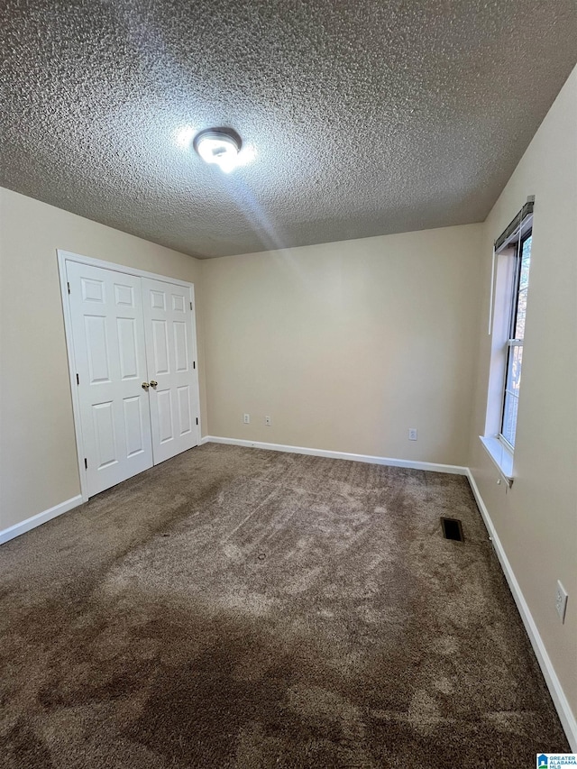 unfurnished bedroom with carpet floors and a textured ceiling