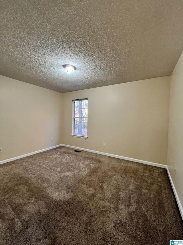 carpeted spare room featuring a textured ceiling