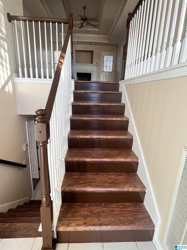 stairs featuring ceiling fan