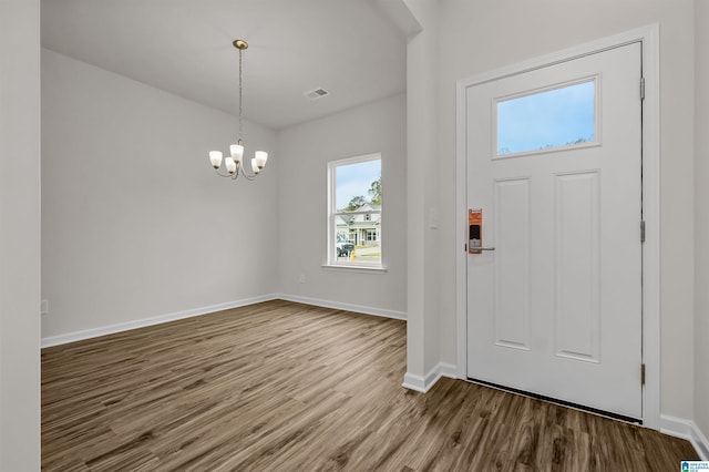 foyer entrance with hardwood / wood-style floors and a notable chandelier