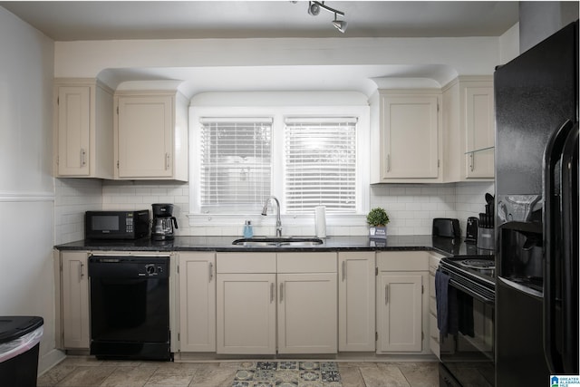 kitchen with backsplash, dark stone counters, sink, black appliances, and cream cabinets