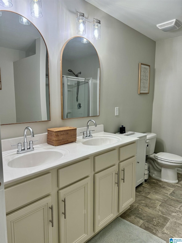 bathroom featuring vanity, toilet, and a shower with shower door