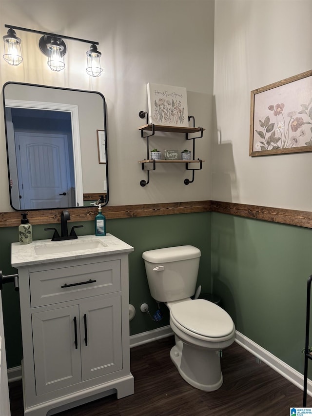 bathroom featuring wood-type flooring, vanity, and toilet