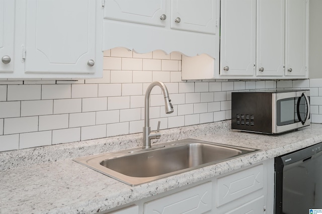 kitchen with tasteful backsplash, white cabinetry, and black dishwasher