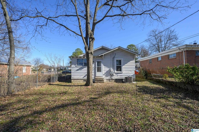 back of property featuring central air condition unit and a yard