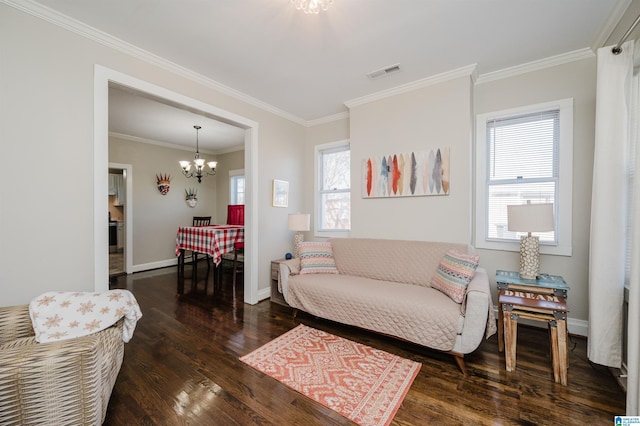 living room with crown molding, dark wood-type flooring, and a chandelier