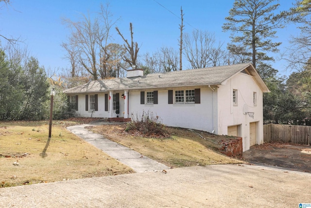 ranch-style house featuring a garage and a front lawn