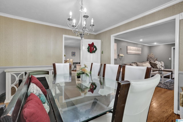 dining room with hardwood / wood-style floors, ornamental molding, and a chandelier