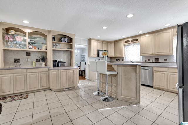 kitchen with a breakfast bar, a center island, light tile patterned floors, and stainless steel appliances