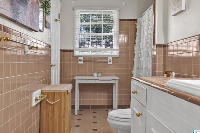 bathroom with tile patterned floors, tile walls, and toilet