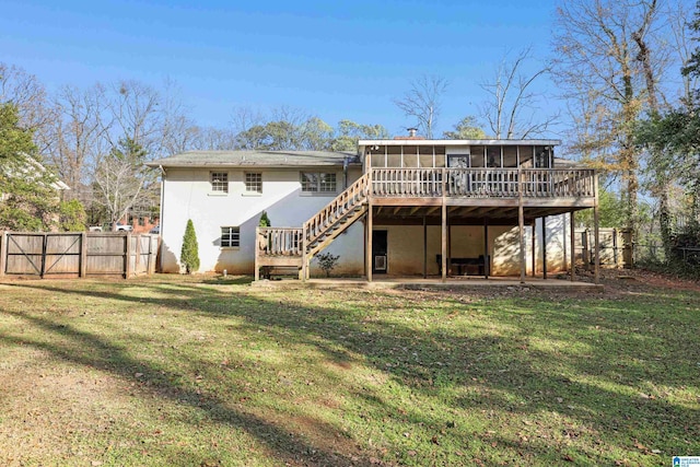 rear view of property featuring a yard, a deck, and a sunroom