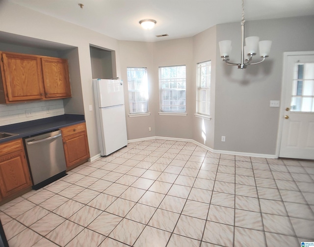 kitchen with stainless steel dishwasher, a notable chandelier, white fridge, decorative backsplash, and light tile patterned flooring