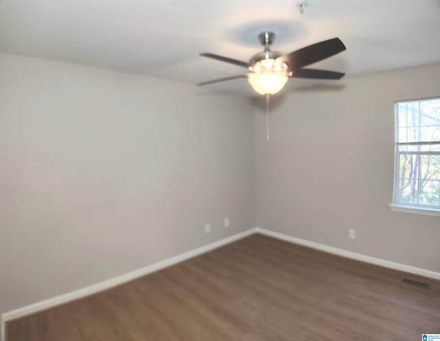 empty room featuring dark hardwood / wood-style flooring and ceiling fan