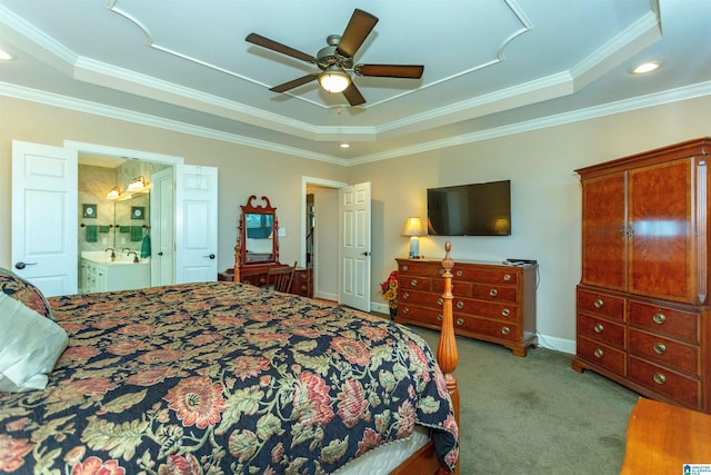 carpeted bedroom featuring ceiling fan, a raised ceiling, ornamental molding, and ensuite bath