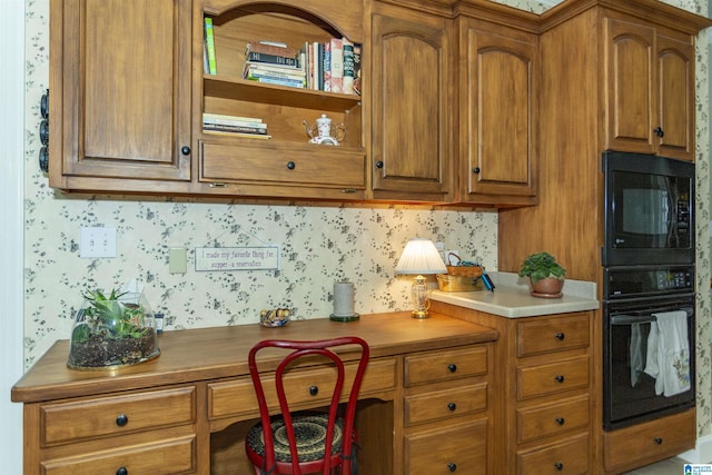 kitchen with built in desk and black appliances