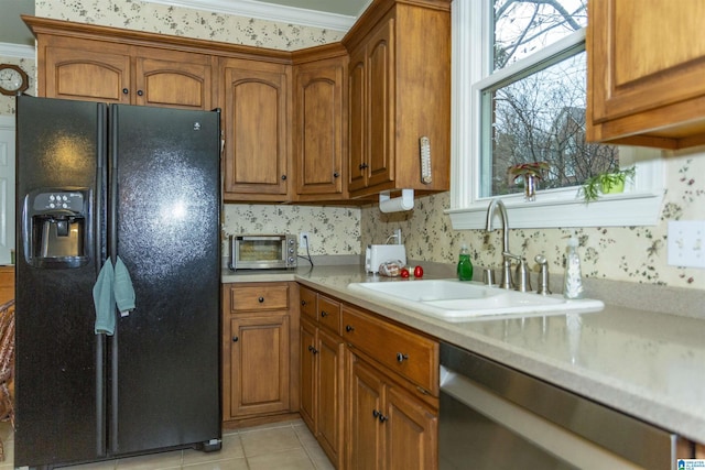 kitchen with black fridge, ornamental molding, sink, light tile patterned floors, and dishwasher