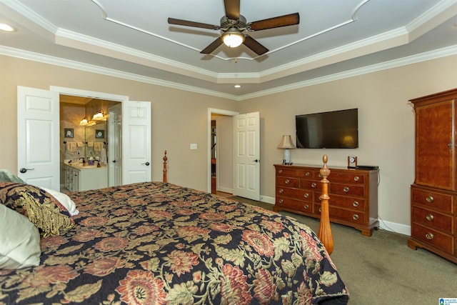 carpeted bedroom with a raised ceiling, connected bathroom, ceiling fan, and ornamental molding