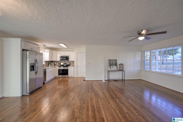 unfurnished living room featuring a textured ceiling, ceiling fan, and dark wood-type flooring