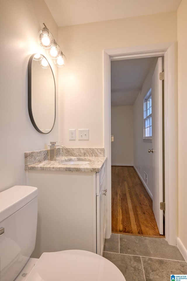 bathroom with tile patterned flooring, vanity, and toilet