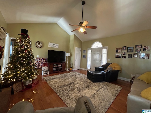 living room with ceiling fan, dark wood-type flooring, and vaulted ceiling