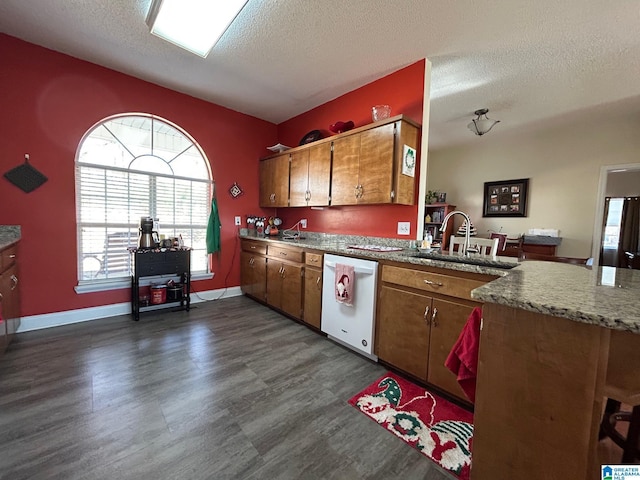 kitchen featuring a textured ceiling, white dishwasher, and sink