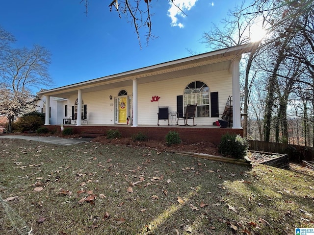 ranch-style home featuring a front lawn and covered porch